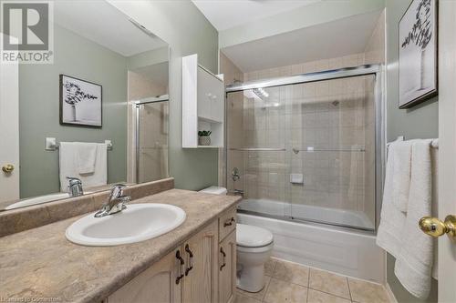 Full bathroom featuring tile patterned flooring, vanity, bath / shower combo with glass door, and toilet - 24 Kenyon Crescent Unit# 45, Grimsby, ON - Indoor Photo Showing Bathroom