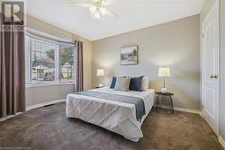 Carpeted bedroom featuring ceiling fan - 