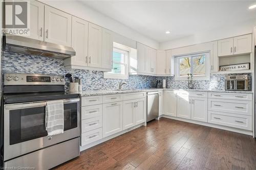 Kitchen featuring decorative backsplash, stainless steel appliances, white cabinetry, and dark hardwood / wood-style floors - 25 Rockwood Avenue, St. Catharines, ON - Indoor Photo Showing Kitchen With Upgraded Kitchen