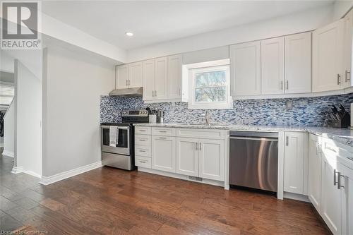 Kitchen featuring dark hardwood / wood-style flooring, white cabinets, and stainless steel appliances - 25 Rockwood Avenue, St. Catharines, ON - Indoor Photo Showing Kitchen With Upgraded Kitchen