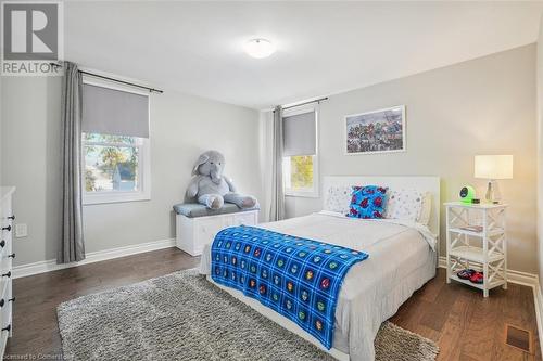 Bedroom featuring dark hardwood / wood-style flooring and multiple windows - 25 Rockwood Avenue, St. Catharines, ON - Indoor Photo Showing Bedroom