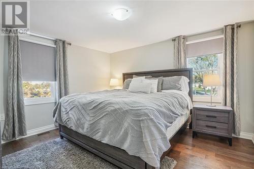 Bedroom featuring multiple windows and dark hardwood / wood-style flooring - 25 Rockwood Avenue, St. Catharines, ON - Indoor Photo Showing Bedroom