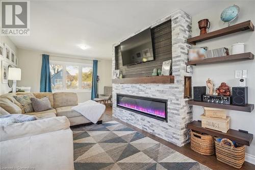 Living room with dark hardwood / wood-style flooring and a large fireplace - 25 Rockwood Avenue, St. Catharines, ON - Indoor Photo Showing Living Room With Fireplace