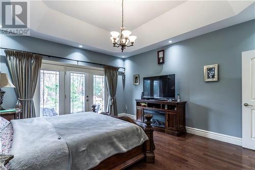 Bedroom featuring dark hardwood / wood-style floors, french doors, access to outside, and a tray ceiling - 59 Dominion Drive, Guelph, ON - Indoor Photo Showing Bedroom