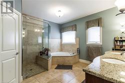 Bathroom featuring tile patterned flooring, vanity, and shower with separate bathtub - 