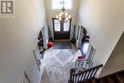 Foyer entrance with a high ceiling, an inviting chandelier, and a healthy amount of sunlight - 