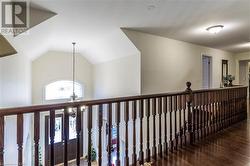 Hall featuring wood-type flooring, vaulted ceiling, and a notable chandelier - 