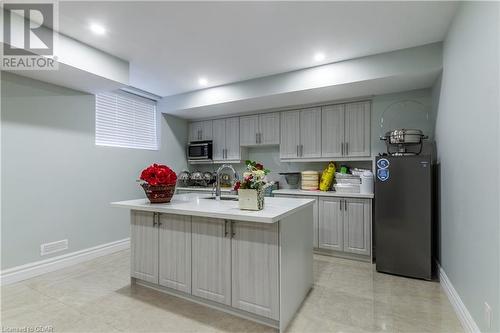 Kitchen featuring sink, gray cabinets, fridge, and a kitchen island with sink - 59 Dominion Drive, Guelph, ON - Indoor Photo Showing Kitchen