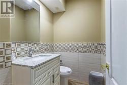 Bathroom with vanity, tile walls, and toilet - 