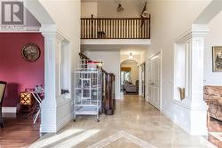 Entrance foyer featuring a high ceiling, light hardwood / wood-style floors, decorative columns, and crown molding - 