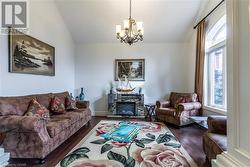 Living room with dark hardwood / wood-style floors, a chandelier, and vaulted ceiling - 