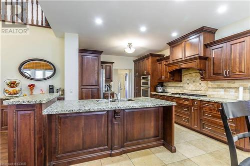 Kitchen with sink, an island with sink, stainless steel appliances, and light tile patterned floors - 59 Dominion Drive, Guelph, ON - Indoor Photo Showing Kitchen