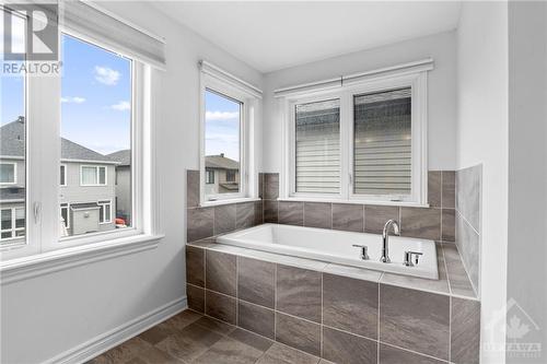 Window surrounded deep soaker tub. - 272 Big Dipper Street, Ottawa, ON - Indoor Photo Showing Bathroom