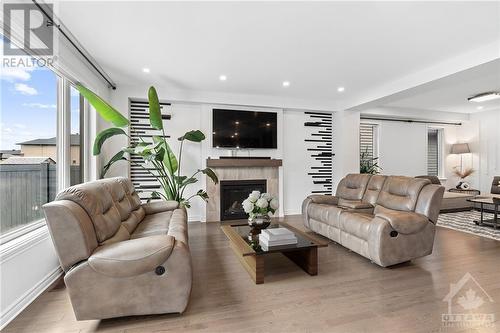 Great room with bright expansive windows & gas fireplace. (Virtually Altered) - 272 Big Dipper Street, Ottawa, ON - Indoor Photo Showing Living Room With Fireplace