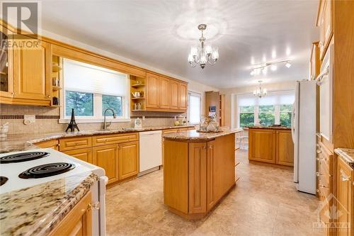 Family-sized kitchen has granite counter tops, island, peninsula breakfast bar and crown moulding - 28 Mountain View Lane, Westport, ON - Indoor Photo Showing Kitchen