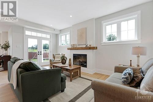 Living room touch-screen multi-colour electric fireplace and garden doors to back yard - 27 Shelter Cove Drive, Westport, ON - Indoor Photo Showing Living Room With Fireplace