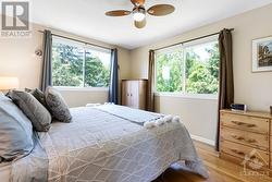 Primary bedroom large windows overlook picturesque yard - 