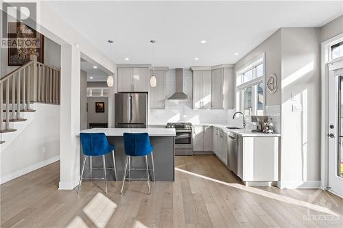 Kitchen includes quartz island w/ breakfast bar seating and elegant tile backsplash. - 68 Hubble Heights, Ottawa, ON - Indoor Photo Showing Kitchen With Upgraded Kitchen