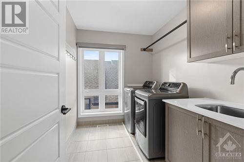 Laundry suite w/ sink and plenty of storage space above. - 68 Hubble Heights, Ottawa, ON - Indoor Photo Showing Laundry Room