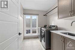 Laundry suite w/ sink and plenty of storage space above. - 