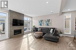 Living room w/ gas fireplace and tons of windows welcoming natural light. - 