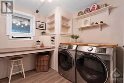 Lower level efficient laundry room with window and on other wall, storage cupboards including sink - 