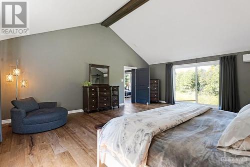 master bedroom with patio door overlooking the backyard and forest - 1608 Nolans Road, Montague, ON - Indoor Photo Showing Bedroom