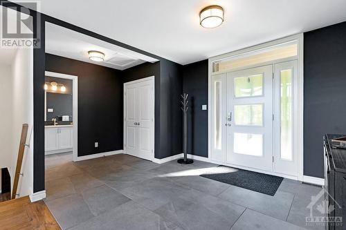 view of the foyer, showing stairs to lower level, front hall closet, and powder room - 1608 Nolans Road, Montague, ON - Indoor Photo Showing Other Room