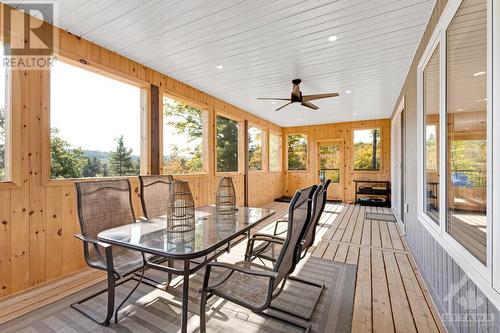 Relaxing three-season sunroom overlooks river and treetops - 1074 Barrett Chute Road, Calabogie, ON - Outdoor With Deck Patio Veranda With Exterior