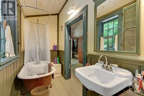 Main floor bathroom has claw tub with shower unit - 161 A Taggart Lane, Westport, ON - Indoor Photo Showing Bathroom