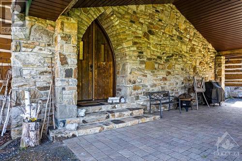 Solid gothic door welcomes you home - 2499 Bathurst Concession 2 Road, Perth, ON - Outdoor With Deck Patio Veranda With Exterior