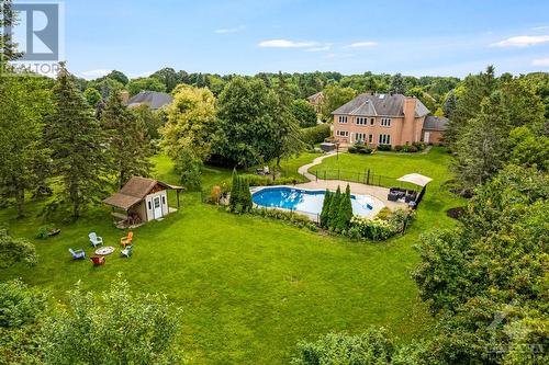 Private lush green backyard retreat with salt-water heated in-ground pool and patio - 5525 Pettapiece Crescent, Manotick, ON - Outdoor With View