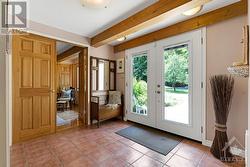 Home's grand front foyer has closet and terracotta ceramic floor flowing into open living spaces - 