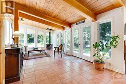 Great Room combined living area and sunroom, both areas wrapped in windows and have woodstove - 