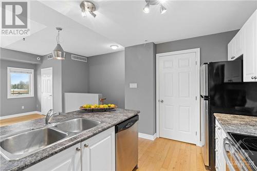 Access to hall closet and stacked in-unit laundry! - 231 Crestway Drive Unit#J, Ottawa, ON - Indoor Photo Showing Kitchen With Double Sink