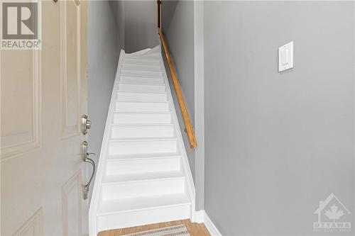 Front foyer entrance with freshly painted stairs up to the main level. - 231 Crestway Drive Unit#J, Ottawa, ON - Indoor Photo Showing Other Room