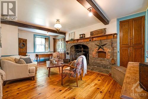 In living room, birdseye maple cabinets flank the handsome stone fireplace with woodstove insert - 1731 Beckwith 7Th Line, Carleton Place, ON - Indoor With Fireplace