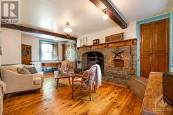 In living room, birdseye maple cabinets flank the handsome stone fireplace with woodstove insert - 