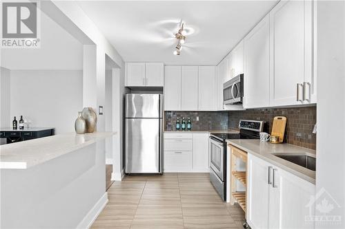 Tiled kitchen w/ breakfast bar opening & quartz counters throughout! - 1505 Baseline Road Unit#511, Ottawa, ON - Indoor Photo Showing Kitchen