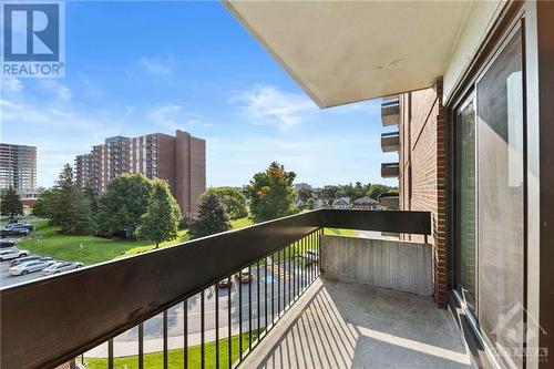 Walkout covered balcony view to the right w/ greenery & front parking lot. - 1505 Baseline Road Unit#511, Ottawa, ON - Outdoor With Balcony With Exterior