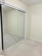 Unfurnished bedroom with a closet and light colored carpet - 