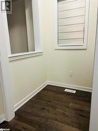 Spare room featuring dark wood-type flooring - 