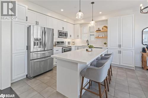 Kitchen featuring white cabinets, a center island, a healthy amount of sunlight, and stainless steel appliances - 19 Mugford Crescent, Brampton, ON - Indoor Photo Showing Kitchen With Upgraded Kitchen