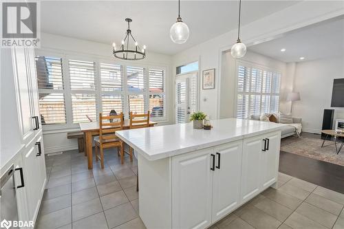 Kitchen with pendant lighting, light hardwood / wood-style floors, white cabinetry, and a wealth of natural light - 19 Mugford Crescent, Brampton, ON - Indoor