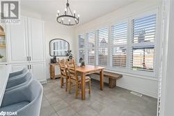 Dining space with a notable chandelier, light tile patterned floors, and a wealth of natural light - 