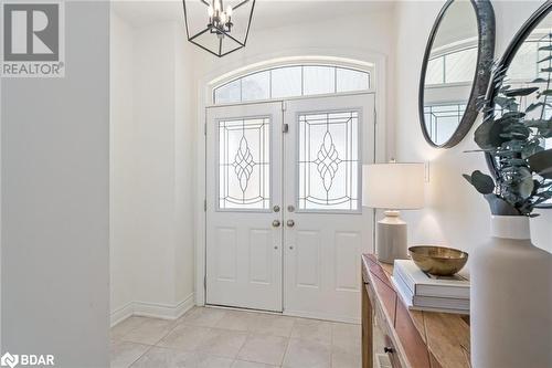 Entrance foyer featuring light tile patterned floors and a healthy amount of sunlight - 19 Mugford Crescent, Brampton, ON - Indoor Photo Showing Other Room