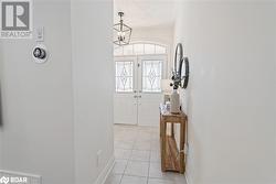 Tiled entryway featuring a notable chandelier - 