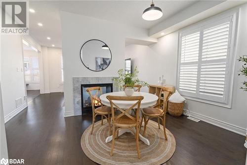 Dining room featuring a multi sided fireplace and dark hardwood / wood-style flooring - 19 Mugford Crescent, Brampton, ON - Indoor Photo Showing Dining Room With Fireplace