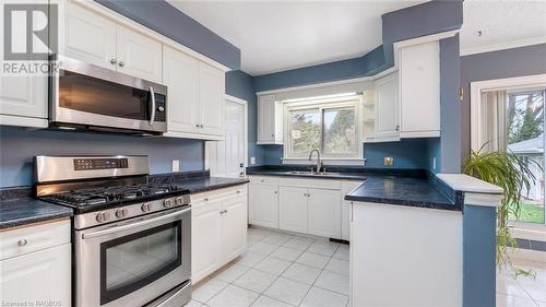 Kitchen featuring a healthy amount of sunlight, white cabinets, and stainless steel appliances - 490 7Th Street W, Owen Sound, ON - Indoor Photo Showing Kitchen With Double Sink