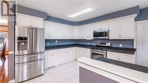 Kitchen with white cabinets, light tile patterned floors, and appliances with stainless steel finishes - 490 7Th Street W, Owen Sound, ON - Indoor Photo Showing Kitchen